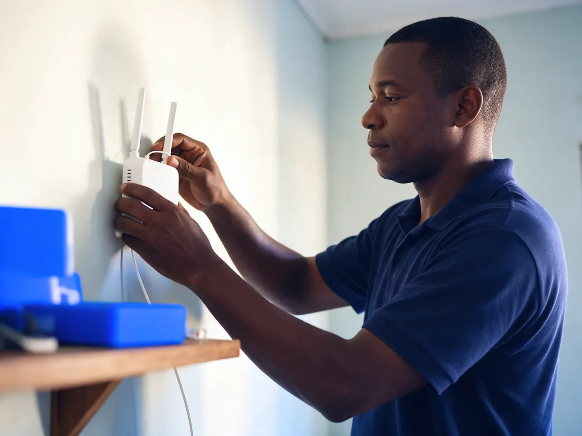 Técnico da Lumi Fibra instalando o roteador na sala de um cliente