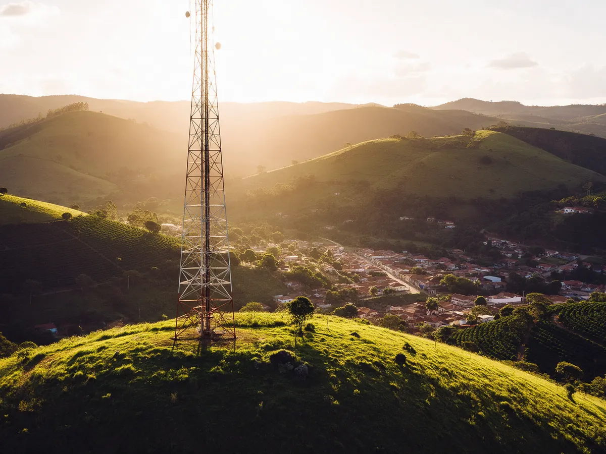 Torre de antena de rádio no alto de um morro, ao fim da tarde